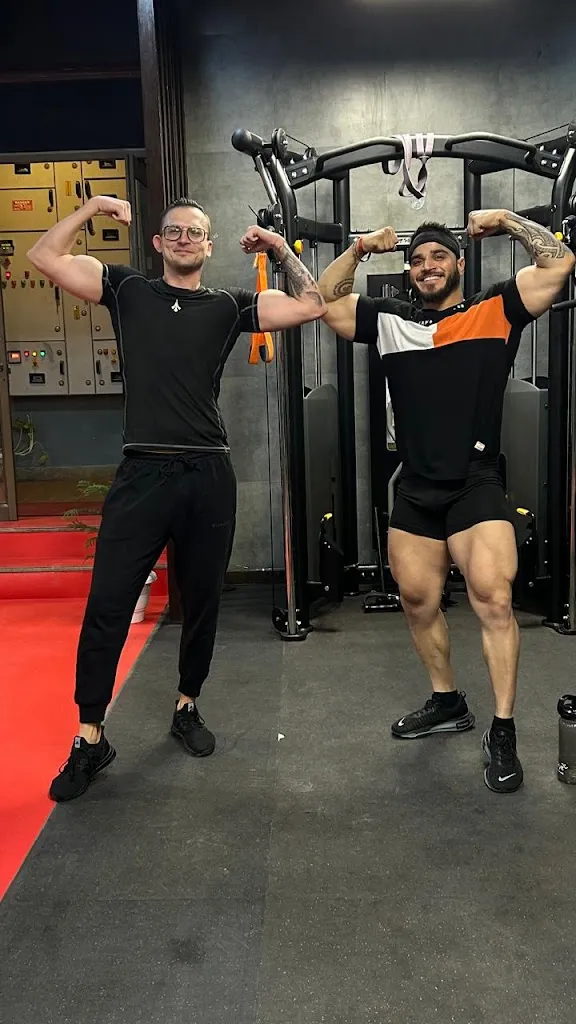Two people training on the cable and resistance machine on the studio floor at AV Fitness Studio.